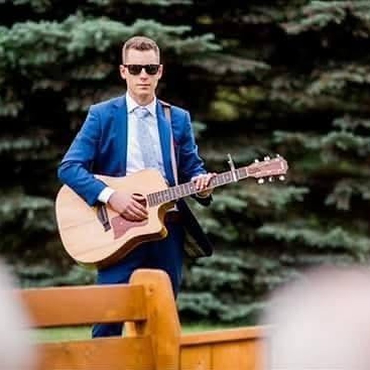 Josh playing acoustic guitar at a wedding ceremony